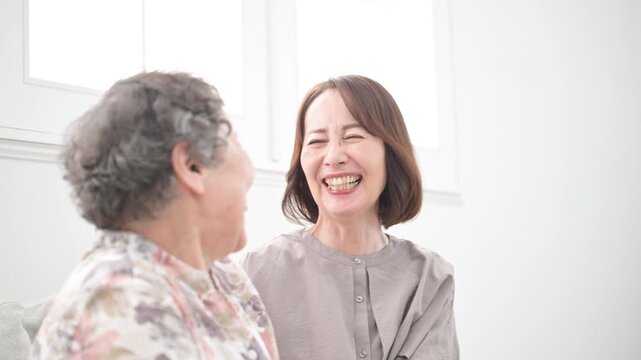 娘と高齢の母の笑顔の寄り添うクローズアップ　介護や親子のイメージの見つめ合う動画　スローモーション