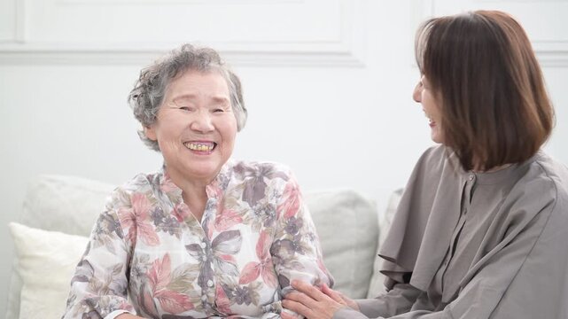 娘と高齢の母の笑顔の寄り添うクローズアップ　介護や親子のイメージの見つめ合う動画