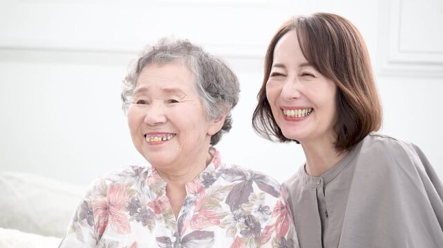 娘と高齢の母の笑顔の寄り添うクローズアップ　介護や親子のイメージの動画　スローモーション