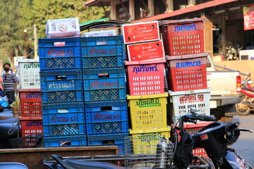 Fototapeta premium Stacked colorful plastic fruit crates and boxes on a motorcycle at a local market.Lampang Thailand, 01 Feb 2026