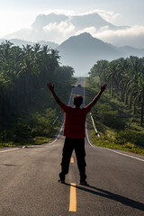 Travel man standing on road in to the mountains