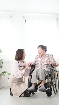 自宅で車椅子の母を介護をする様子　見つめ合う会話するコミュニケーションの在宅介護のイメージの縦動画　スローモーション
