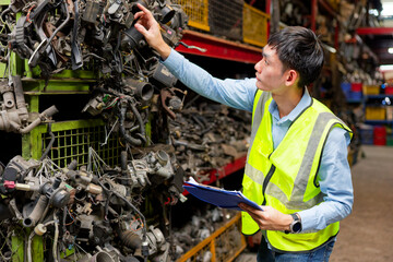 Worker examines a pile of metallic parts and debris in the factory
