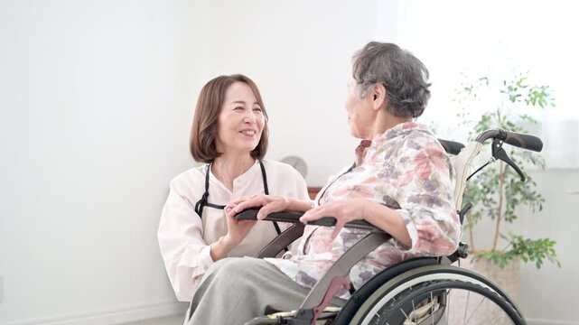 自宅で車椅子の母を介護をする様子　見つめ合う会話するコミュニケーションの在宅介護のイメージの動画　スローモーション