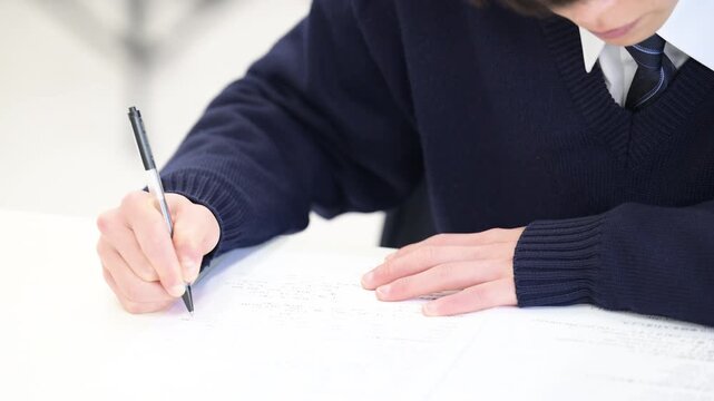 学校や塾などで受験対策の模試のテストを受ける日本人の高校生の男女の動画　顔なしの手元のクローズアップ(英語プリントのプロパティリリースあり）