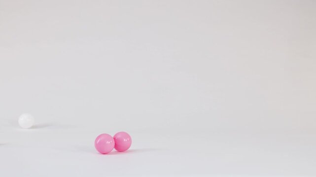 Colorful Plastic Spheres Falling and Bouncing on a White Background