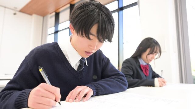 学校や塾などで受験対策の模試のテストを受ける日本人の高校生の男女の動画(英語プリントのプロパティリリースあり）