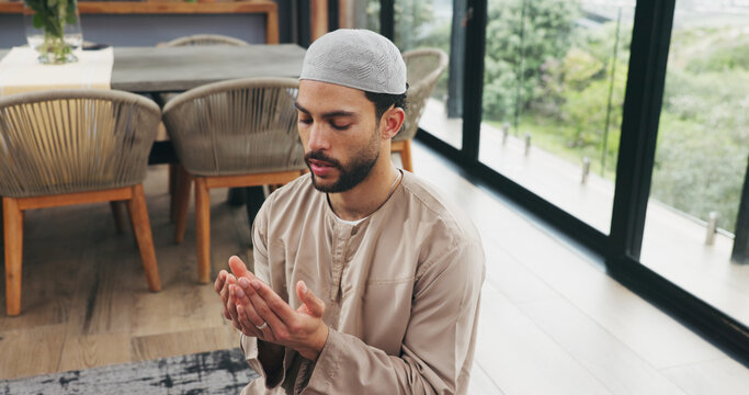 Muslim, man and praying with dua at house for faith, praise Allah and spiritual worship in Ramadan. Male person, thobe and prayer with salah, religious practice and devotion to God for Islamic belief