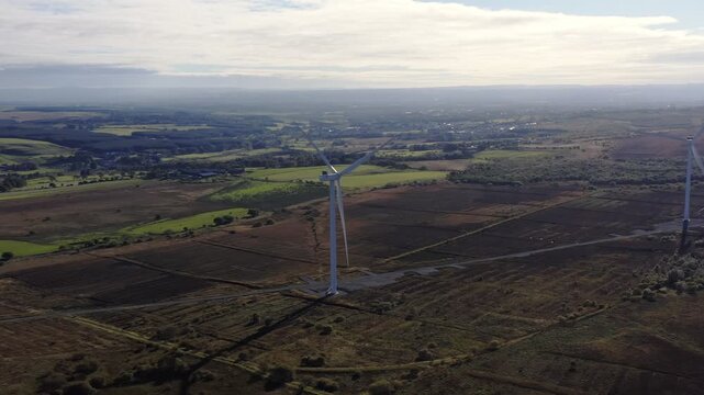 Drone shot of wind turbines turning at Greengairs East Wind Farm in Scotland.