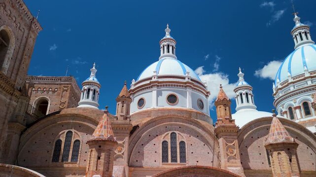 Detailed aerial orbit of the Cathedral of the Immaculate Conception highlighting truncated brick towers, Romanesque arches, and pink Carrara marble accents in Cuenca