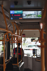 Obraz premium Interior view of TransJakarta bus with passengers and digital route screen commuting in Jakarta city center, Indonesia