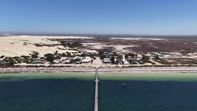 Fowlers Bay jetty, South Australia &ndash; 4K aerial drone view of Great Australian Bight coastline, caravan park, turquoise ocean, sand dunes, white sand beach and limestone cliffs