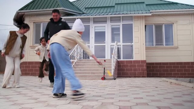Two children play with skipping rope outdoors near modern private house. Happy siblings enjoy active fun together, symbolizing carefree childhood, family lifestyle on bright day.. Authentic everyday