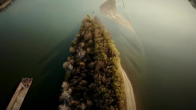 Aerial dolly over forested rocky island ridge surrounded by calm Adriatic Sea in warm evening light, golden hour backdrop