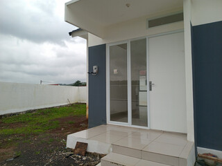 Modern house entrance with glass door and tiled steps