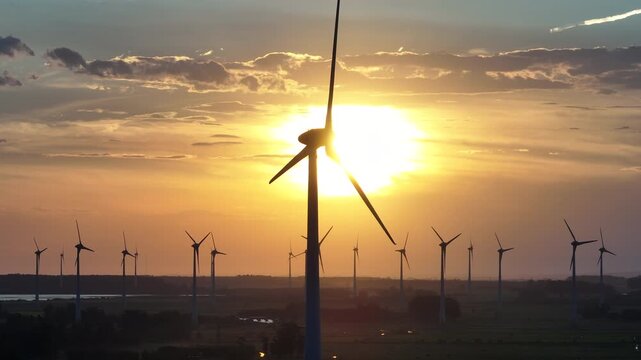 Cinematic aerial telephoto parallax of a wind turbine silhouette with the sun passing behind at sunset in Imbe, Brazil. 4K 10-bit ProRes 50fps.