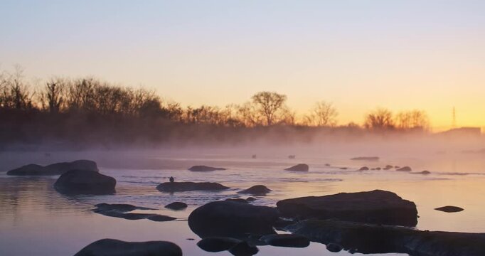 Steam Rising Above River at Sunrise With Birds in Soft Morning Light