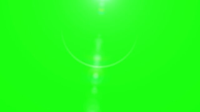Bright cinematic lens flare effect shimmering gently downwards over a vibrant chroma key green screen background providing perfect visual space for creative post production video compositing needs