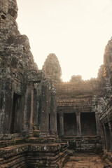 Naklejka premium Ancient Bayon Temple Courtyard at Sunrise with Stone Faces in Cambodia
