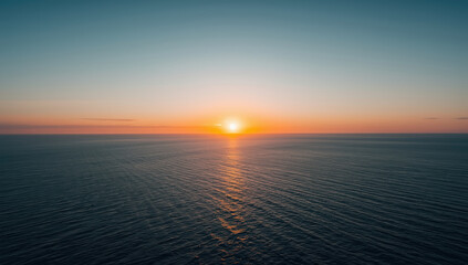 Obraz premium Serene ocean sunset, horizon glow, warm sky, calm water