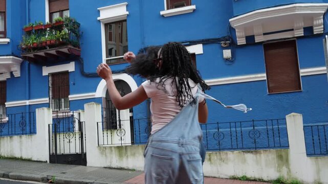 Young afro latino couple having fun dancing salsa in slow motion. Joyful man and woman enjoying a romantic and happy moment outdoors