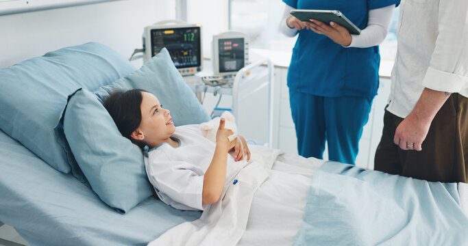 Happy, child and girl with teddy bear, hospital and nurse with tablet for diagnosis or consultation. Sick, kid and smile on bed with plush toy, dad and discussion with medical professional in clinic