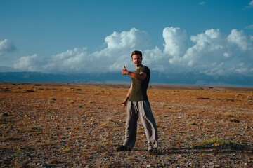 Happy young man giving thumbs up outdoors
