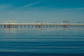 Calm lake with pier on the horizon