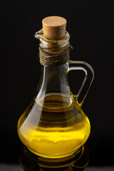 Organic olive oil in jug on black background
