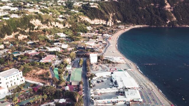 Overhead aerial view of Ischia Citara Beach at sunset with pools and sand