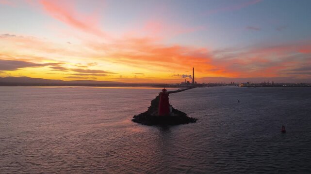 4K cinematic drone footage capturing the iconic Poolbeg Lighthouse and Poolbeg Chimneys in Dublin during a breathtaking sunset, bathed in intense golden-hour colours_57