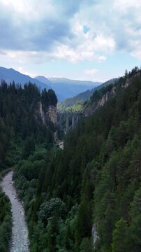 Landwasser Viaduct famous railway bridge in the Swiss Alps Switzerland aerial drone vertical video
