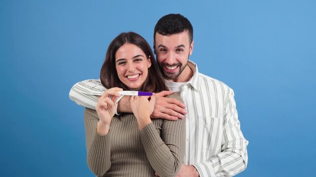 Happy couple expressing their elation while holding a pregnancy test, celebrating a wonderful moment filled with joy and excitement about their future together and the prospect of becoming parents.