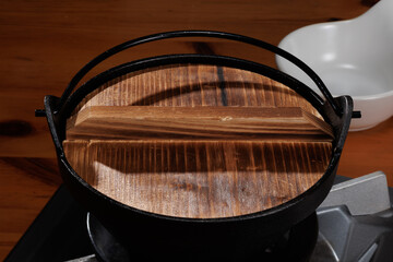 カセットコンロに置かれた蓋付きの鍋