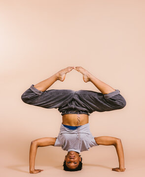 Black woman dancer in headstand pose with pointed feet