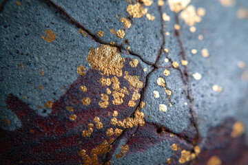 Obraz premium handcrafted ceramic glaze texture in deep slate blue with muted indigo and smoky burgundy undertones, featuring expressive natural crack lines filled with luminous gold metallic accents