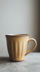 Obraz premium Yellow Ribbed Mug On Light Gray Surface