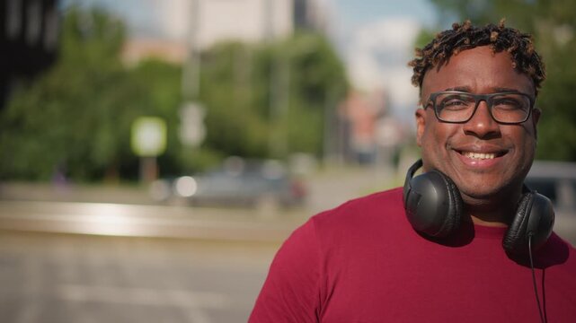 person with headphones on sunlit street, closeup portrait showing thoughtful expressions and casual style frames suggest street DJ scouting beats, busker taking a break, producer listening