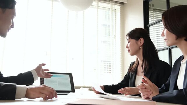 笑顔で会議をする3人の日本人男女