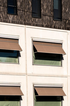 Minimal modern architecture facade with brick windows and awnings capturing urban geometry and clean lines in a simple exterior detail view