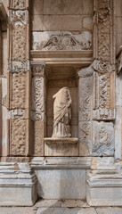 Obraz premium Headless statue of Ennoia at the Library of Celsus, ancient Roman ruins in Ephesus, Turkey. Intricate stone carvings and historical architecture