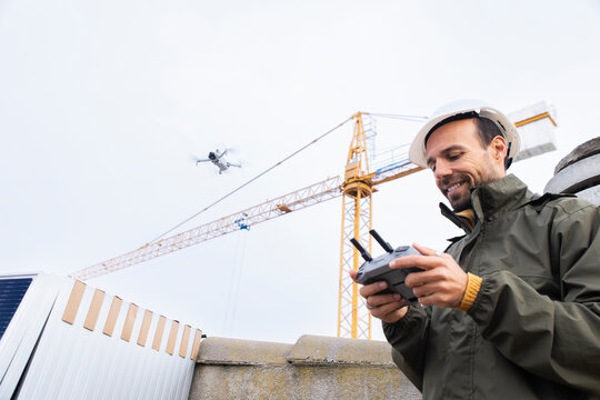 Engineer operating drone for aerial inspection on rooftop construction site