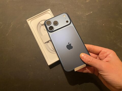 Palma, spain, january 20, 2026, hand holding apple iphone 15 pro blue titanium unboxing a new smartphone with usb c cable in packaging