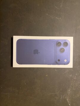 Palma, spain, january 20, 2026, apple iphone box on dark surface showcasing purple smartphone rear with triple camera and iconic apple logo, studio flat lay