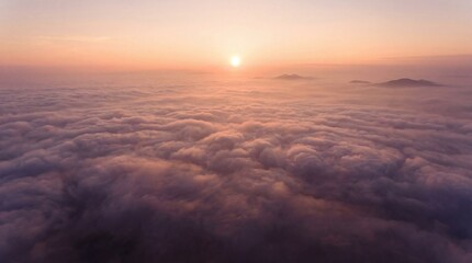 Fototapeta premium Sunrise over clouds with distant mountains viewed from above early in the morning