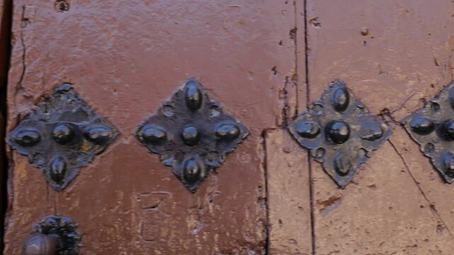 Close-up of the decorative wrought iron nails on the old wooden door of the Carmen Convent.