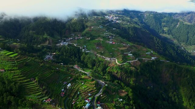 Aerial over Halsema Highway Atok Benguet Philippines highlighting winding roads and cultivated vegetable fields