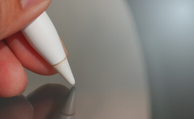 Macro shot of a digital pen tip touching a glass tablet surface.