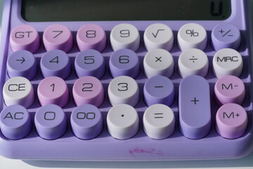 Stylish purple pastel calculator on a desk, modern office stationery.