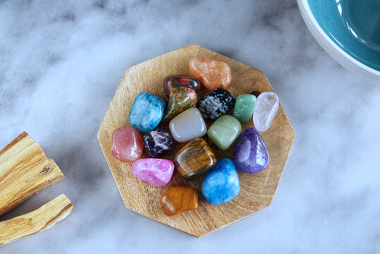 Colorful Healing Crystals on Wooden Plate, Flat Lay on Marble Background